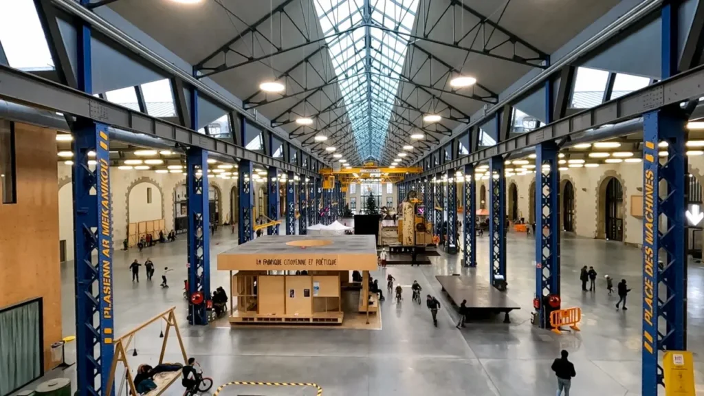 Plaza intérieure des Ateliers des Capucins avec toit en verre, charpente d'acier et vaste espace ouvert pour activités
