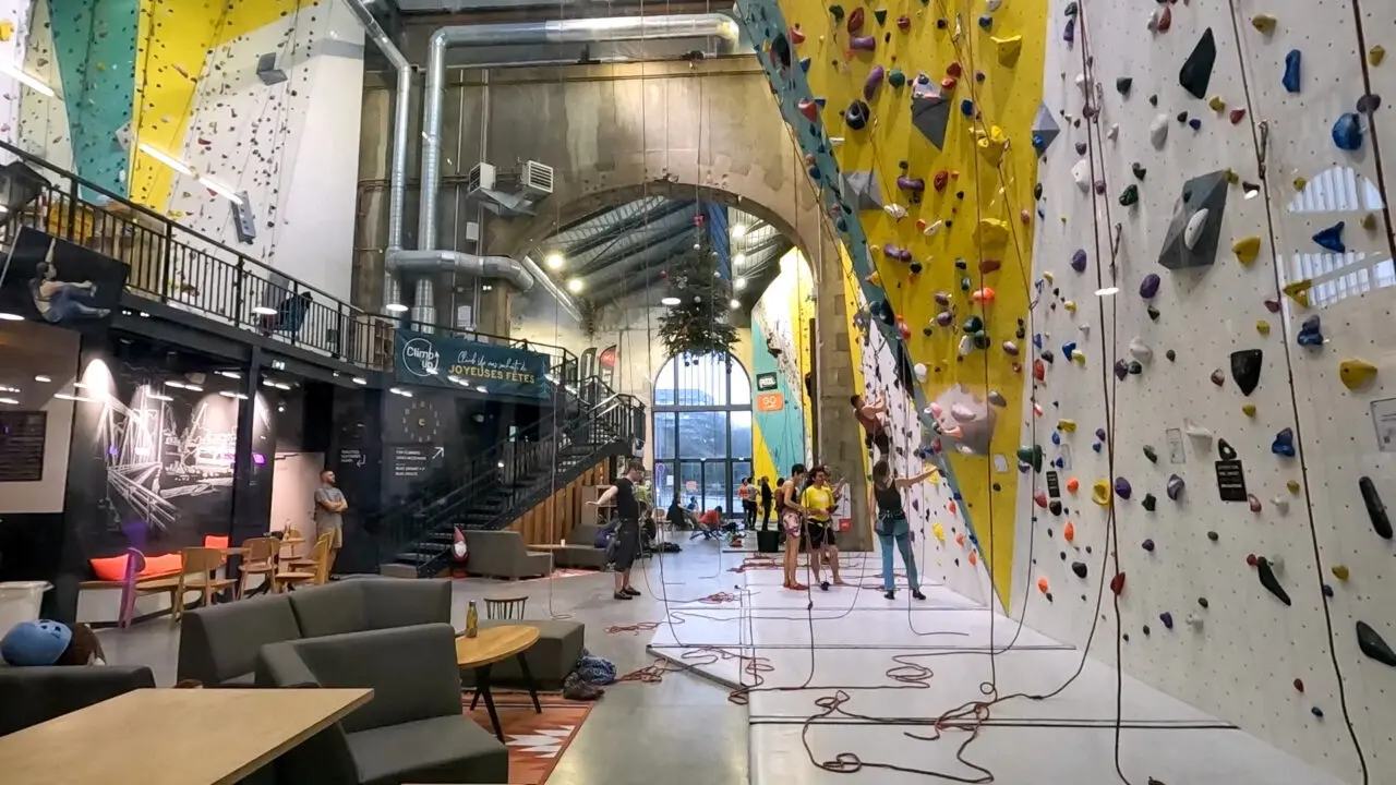 Salle d'escalade intérieure dans Les Ateliers des Capucins avec murs d'escalade artificiels colorés et équipement de sécurité