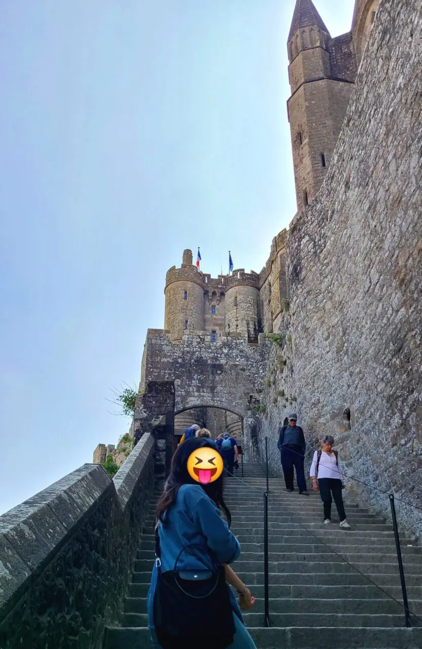 Escaliers de pierre finaux menant à l'entrée de l'abbaye du Mont Saint-Michel avec murs de forteresse médiévaux et tours
