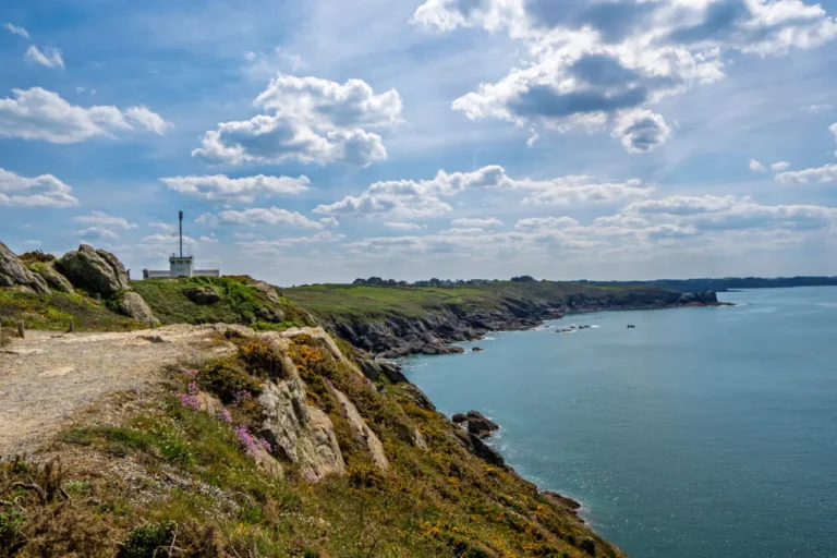 Phare de la Pointe du Grouin et station de signalisation surplombant la côte bretonne dramatique avec fleurs sauvages et sentiers de randonnée près de Cancale, France