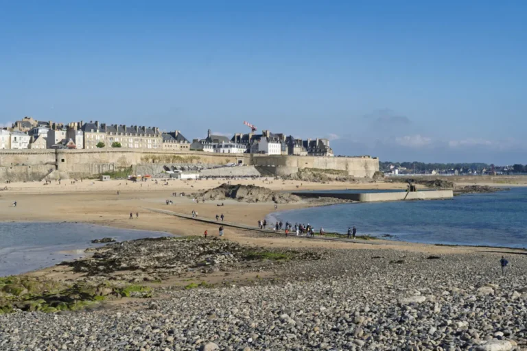 Vue de la plage Bon-Secours et Saint-Malo depuis Grand Bé mettant en valeur la piscine d'eau de mer et le paysage urbain historique