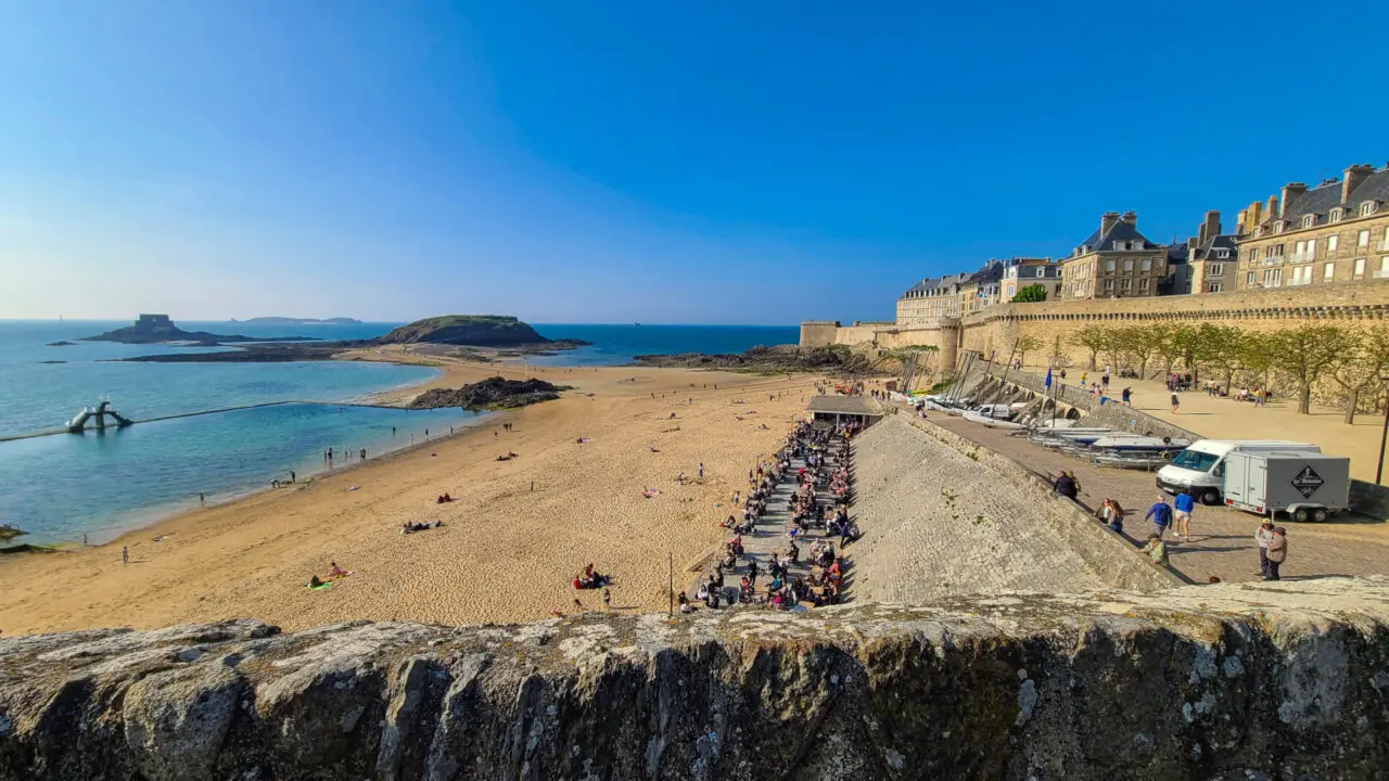 Vue depuis les remparts de Saint-Malo surplombant la plage animée de Bon-Secours avec des foules de gens