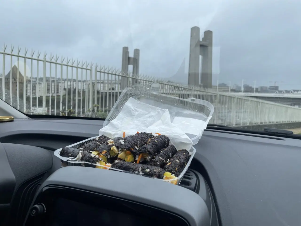 Kimbap fait maison déchiré dans voiture avec pont de Recouvrance visible en arrière-plan à Brest